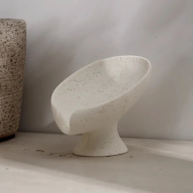 Speckled beige stone soap holder on a neutral background