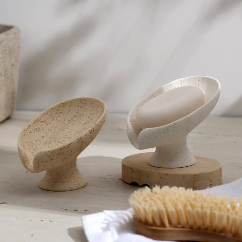 Two Stone soap holders objects on wooden stands with a natural background